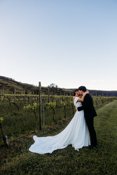 Bride and groom share an intimate moment during sunset portraits at Lake George Winery NSW. Photo by Acacia and Grace Photographer