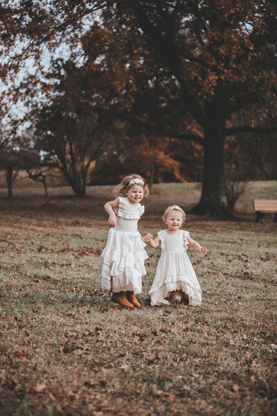 Family Portraits of toddler sisters holding hands