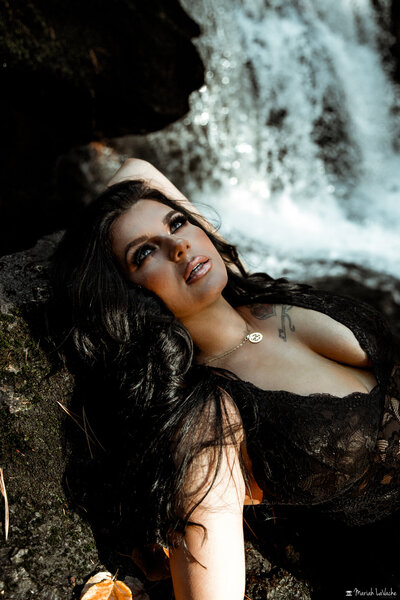 woman posing near waterfall
