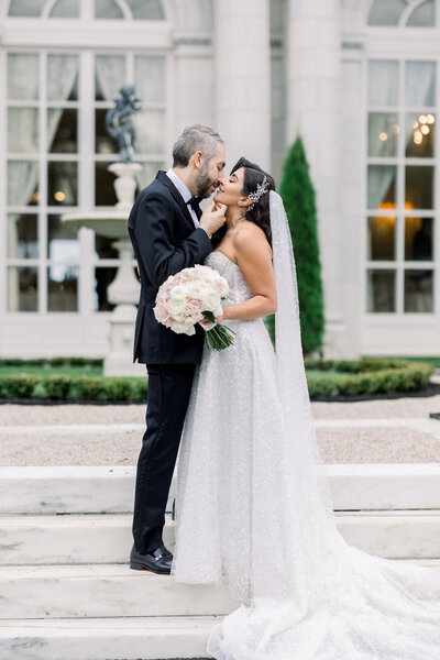 bride and groom posing on stone steps at Rosecliff mansion in Newprt, RI