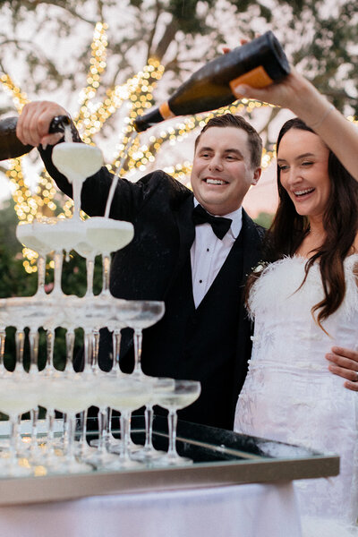 Bride and groom pouring champagne tower at The Club at The Strand