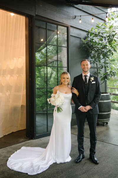 Bride and groom standing at the entrance of JM Cellars in Woodinville, Washington, planned by Wander Event Co., Seattle wedding planner.