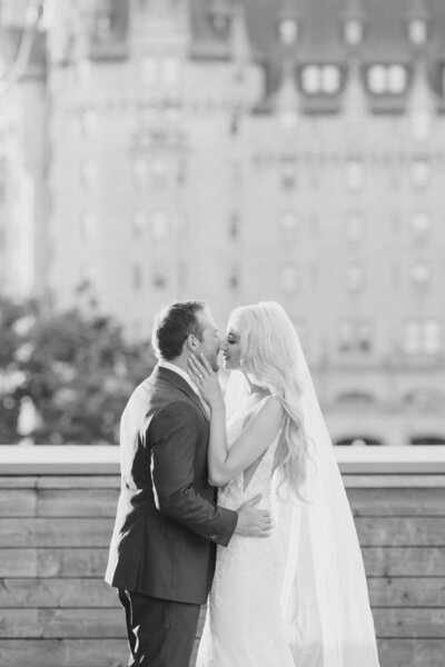 Black and white portrait of a bride and groom kissing at National Arts Centre in Ottawa