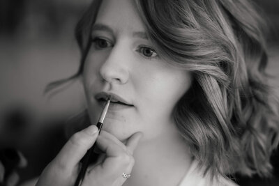 Portret van bruid waarbij makeup gedaan wordt, vastgelegd door trouwfotograaf Julia de Groot