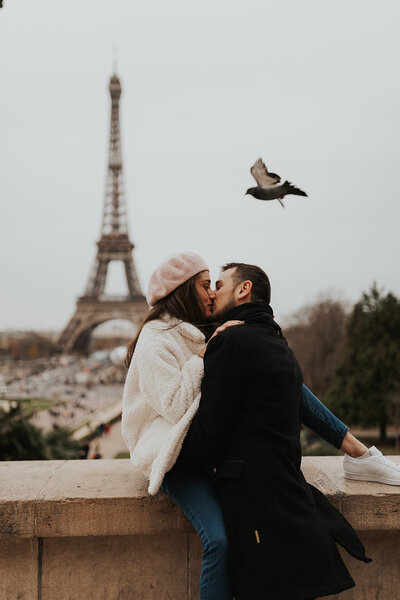couple kissing in front of eiffel tower
