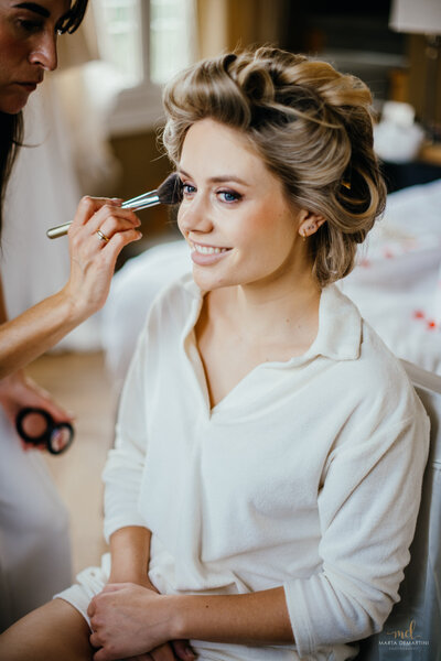 Bruid krijgt haar bruidsmake-up.