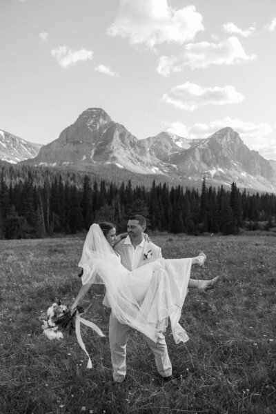 a couple celebrating their love in a field in glacier national park 