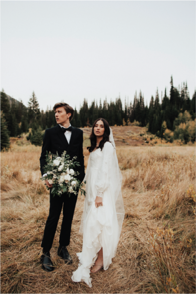 bride-groom-in-front-of-evergreens