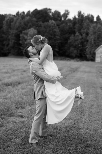 Girl being lifted in the air by her husband during couples portraits