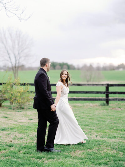 Bride and groom walking hand in hand at their wedding in Sylvanside Farm in Purcellville, VA.