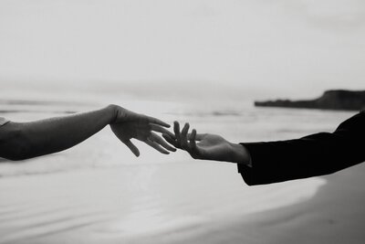 two hands entwining on beach