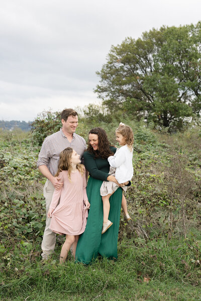 family laughing and posing for portraits at Sculpture Fields