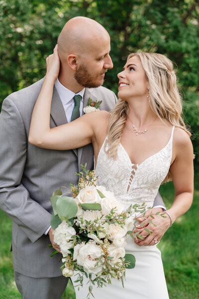 Bride and groom smiling together during an outdoor wedding portrait, capturing their joy and love