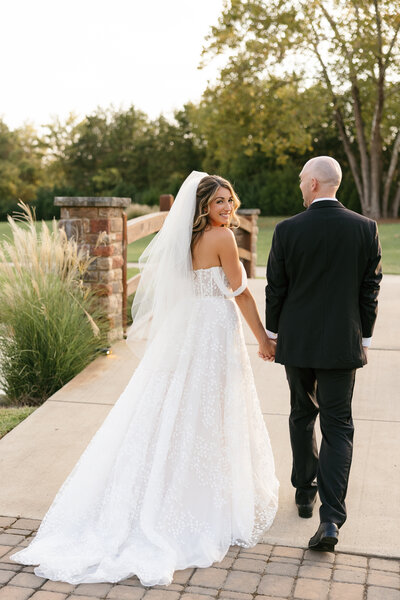 Bride and groom walking together at vibrant Sycamore Farms wedding