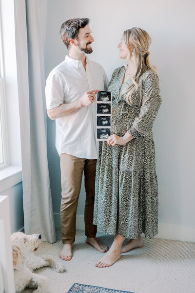 Couple holds an ultrasound during an indoor maternity session.