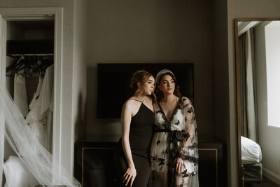 Bride and bridesmaid sharing a quiet getting-ready moment before the wedding ceremony, captured in soft natural light by Rainstorm Photo & Video.