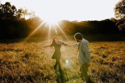 Romantic golden hour engagement photos in a sunlit meadow, taken by a West Michigan photographer.