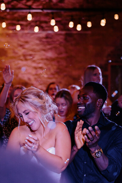 Newlyweds and guests dancing at a reception