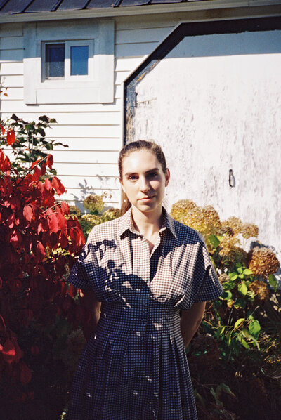 woman in front of red leaves at sugarbush maple farm near woodstock vermont