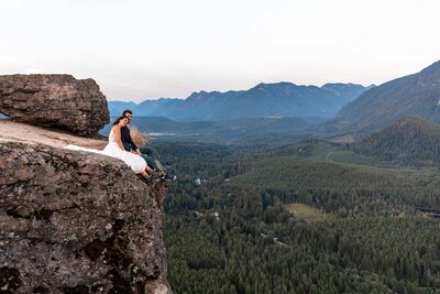 a person is standing on a rock with green valley background