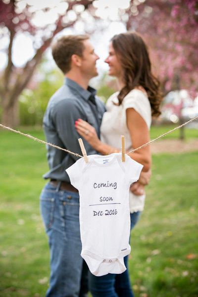 Expecting couple pose for a photo in Washington Park Denver