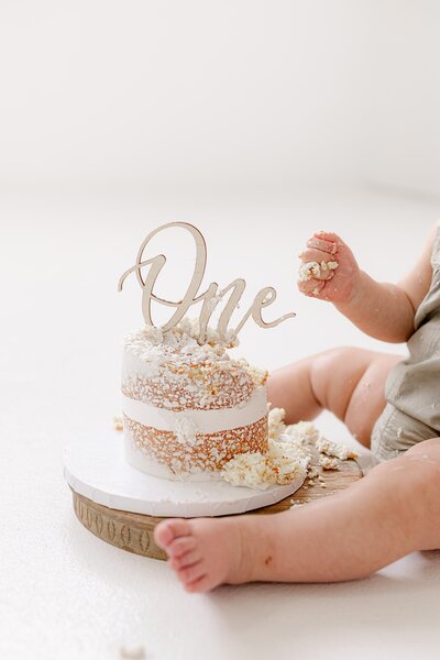 Denver cake smash photography session with baby celebrating their 1st birthday in a minimalist studio setup.