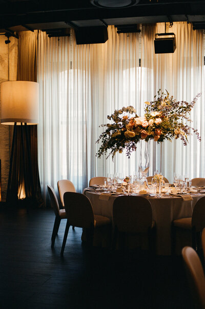 Indoor Chicago venue hall decorated with fall-toned wedding flowers and table decor.