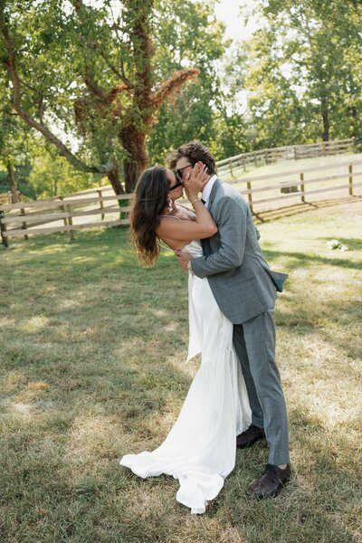 Bride and Groom kissing in a field