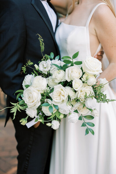 Chic wedding bouquet with white peonies, roses, and a touch of greenery by Leigh Florist for a Downtown Club wedding.