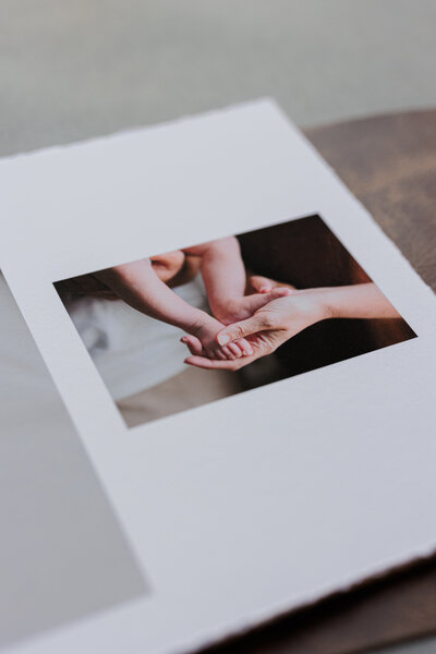 Family heirloom album with a picture of a mom holding baby's feet