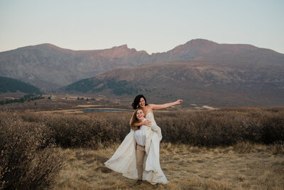Lesbian couple laughs together during their elopement in the Colorado mountains