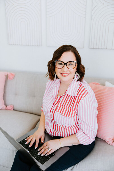 Copywriter Sara Gillis standing in front of a wallpapered wall