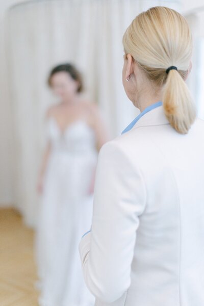 Bride trying on her bespoke wedding gown accompanied by ECLAT Destination Weddings