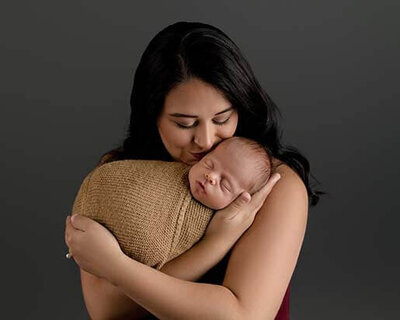New mother holding swaddled newborn.