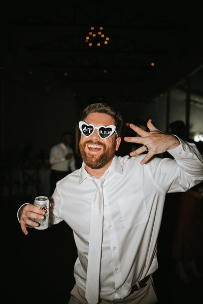 Bride holding her bouquet full of greenery and pink and yellow colors.