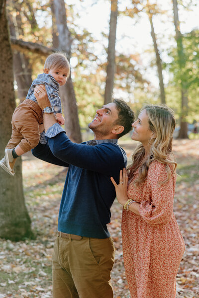 A husband and wife holding and looking at their son