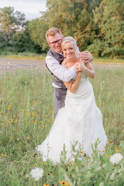 Groom hugging wife