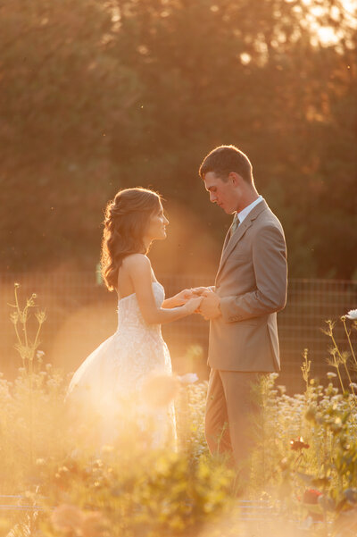 Bride and groom holding hands in a flower garden taken by wedding photographer Boise
