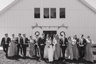 bridal party standing in front of large while building