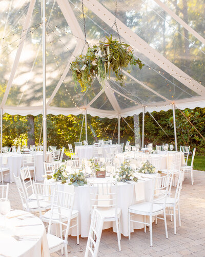 Tented wedding reception table scapes and hanging floral details.
