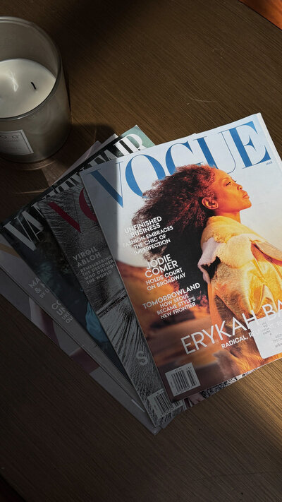 Stack of fashion magazine on a wooden surface