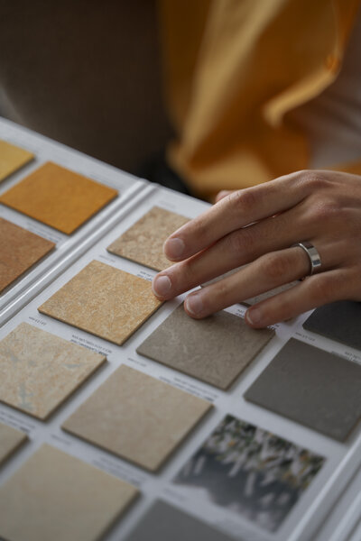 Hand selecting material samples for an interior design project.