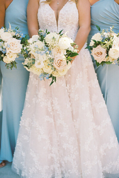 bridesmaids holding bouquets with blue dresses