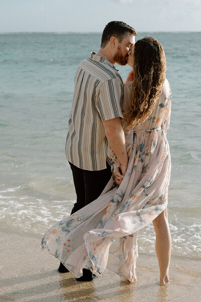 engaged couple walks into ocean in Hawaii