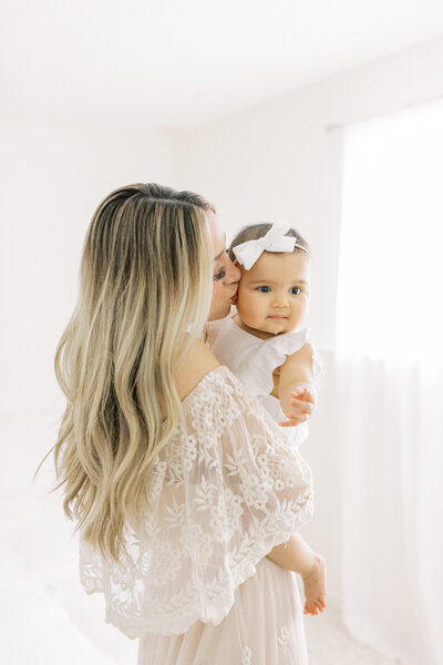 photo of mom kissing daughter taken by a family photographers near me