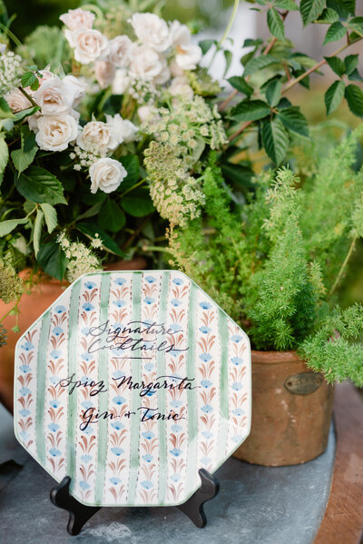 Signature cocktail menu  in calligraphy on a vintage plate for wedding at Lion Rock Farm in Connecticut