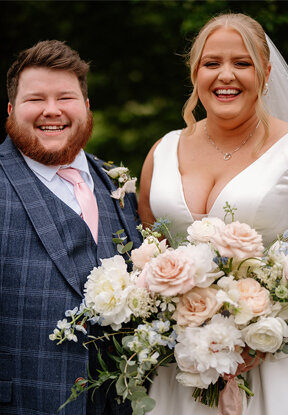 Bride and groom sharing happy moment, bride holding beautiful bouquet