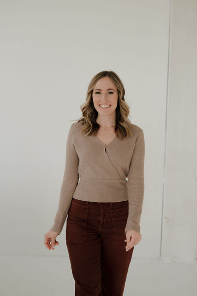 event planner milwaukee wi for Dream Weddings, Molly, smiles at the camera with one hand in her back jeans pocket and the other holding her hair.