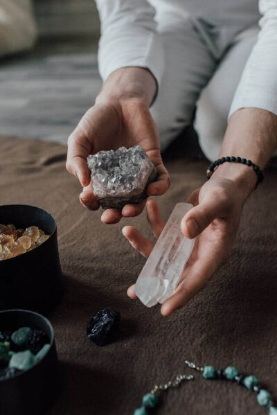 Woman's hands holding crystals for white start reiki and retreats