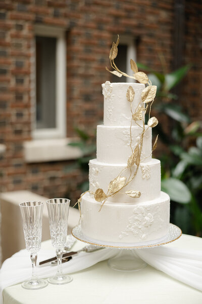 white wedding cake with gold leaf detailing